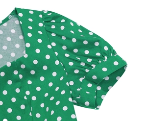 Detail view of retro green polka dot dress with square neck and puffed short sleeves