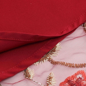 Close-up of red embroidered mesh detail with floral patterns on vintage dress