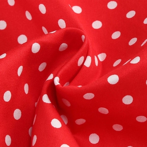 Macro detail of red and white polka dot fabric with soft texture and natural folds
