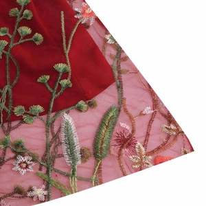 Close-up of intricate red floral embroidery on mesh fabric of the vintage dress