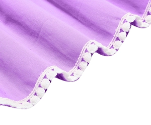 Dettaglio tessuto viola con balza e bordo di pompon bianchi per abito estivo da bambina