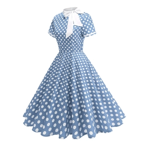Detail of vintage blue dress showing white polka dots and a large bow on the neckline
