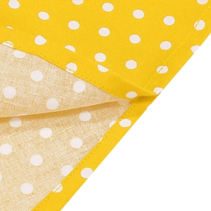 Detailansicht von gelbem Polka-Dot-Stoff mit sauberer Saumnaht und feiner Textur