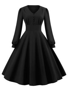 Dettaglio dell'abito vintage nero con scollo a V, bottoni decorativi e vita stretta