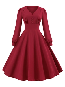 Dettaglio dell'abito vintage bordeaux con scollo a V, bottoni e gonna a pieghe svasata