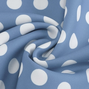 Macro shot of sky blue polka dot fabric with soft texture and elegant drape detail