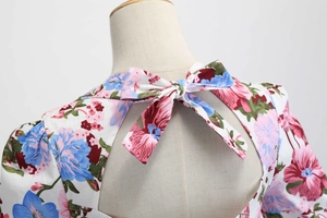 Dettaglio del vestito a fiori con grande fiocco e elegante apertura a triangolo sulla schiena