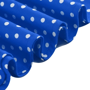 Detailed macro view of the royal blue fabric with white polka dots and pleated hemline