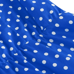 Macro view of blue fabric featuring white polka dots and fine woven texture details