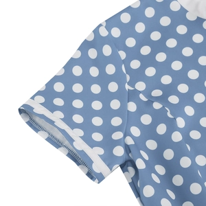Detailed close-up of blue polka dot fabric with white cuff binding and fine stitching