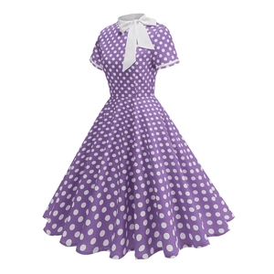 Detail of vintage purple polka dot dress featuring a classic white bow tie neckline