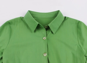 Gros plan du col standard et de la patte de boutonnage sur cette robe rétro vert vif