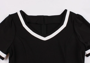 Detail of vintage black dress with white contrast stripes on V-neck and sleeves