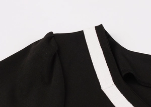 Detail shot of the black vintage floral dress showing premium neckline stitching and white trim