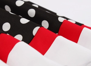Macro detail of pleated fabric in black polka dots, solid red and crisp white