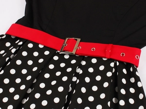 Detail of vintage dress featuring a red adjustable belt with silver buckle and polka dot skirt