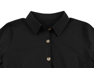 Détail d'une robe noire vintage avec col classique et boutons à texture de marbre
