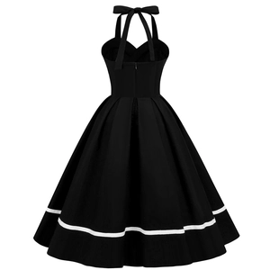 Detail of vintage black halter neck dress featuring a large bow tie and a white stripe hem