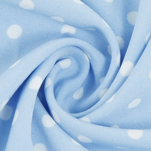 Macro shot of sky blue polka dot fabric with smooth texture and soft pleats