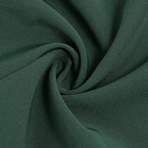 Détail de la texture du tissu vert foncé avec drapé élégant et finition mate pour robe