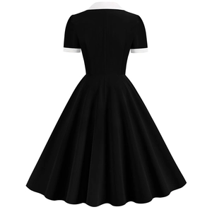 Detail view of the back of a vintage black A-line dress with white contrast collar and cuffs