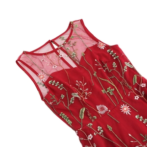 Detail of red sleeveless dress featuring intricate floral embroidery and mesh neckline