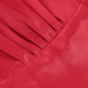 Détail macro du tissu de robe rouge à col en V montrant des plis fins et du satin soyeux