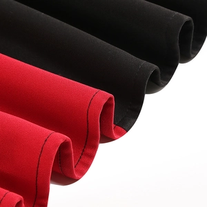 Macro detail of red and black twill fabric with neat stitching on a vintage dress