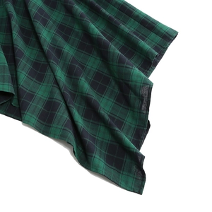 Detailed view of green and black plaid fabric showing high-quality texture and drape
