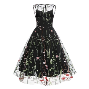 Detail of colorful wildflower embroidery on black mesh overlay of a vintage 50s dress