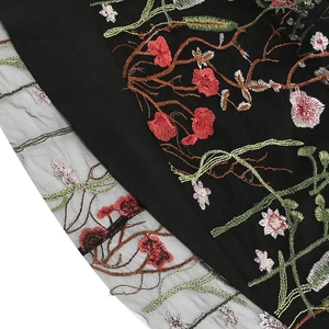 Detail of multi-color floral embroidery on black mesh fabric for elegant dresses