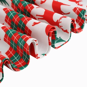 Detailed close-up of festive Christmas print with red reindeer and green pine on dress