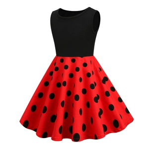 Detail view of the red and black polka dot pattern on the sleeveless girls' dress skirt