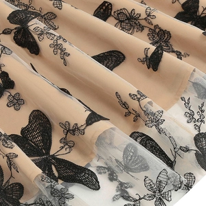 Gros plan sur maille blanche vintage avec broderies complexes de papillons et fleurs noires