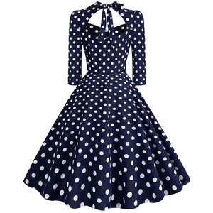 Detail of vintage navy blue polka dot dress featuring a heart-shaped cutout back with a bow