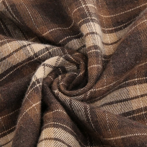 Detailed macro view of the brown plaid fabric showing the twill weave texture