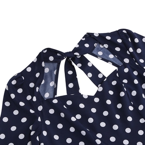 Detail of vintage navy blue polka dot dress featuring a bow tie and square neckline design