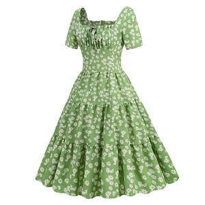 Détail du décolleté carré avec nœud et robe verte à fleurs marguerites à volants