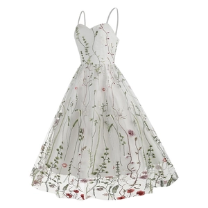 Close-up of white mesh dress with intricate red floral embroidery and slim straps