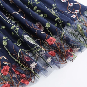 Close-up of vibrant floral embroidery on navy mesh fabric of a summer dress