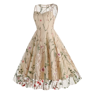 Close-up of intricate colorful floral embroidery on champagne tulle sleeveless dress