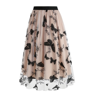 Detail of elegant mesh tulle skirt featuring delicate black butterfly embroidery and waistband