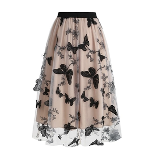 Detail of mesh skirt featuring 3D black butterfly embroidery and elastic waistband