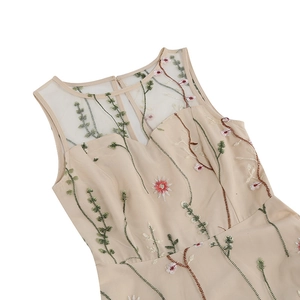 Detail showing sheer mesh neckline with delicate floral embroidery on apricot dress