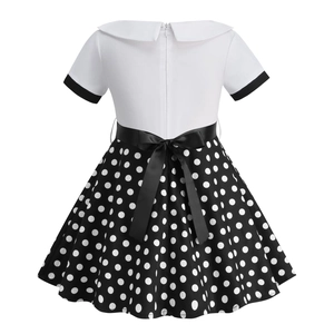 Rear view of white Peter Pan collar dress with black polka dot skirt and satin bow belt