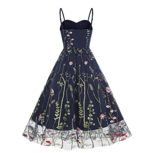 Detail of multi-color floral embroidery and sheer black mesh hem on a navy A-line dress