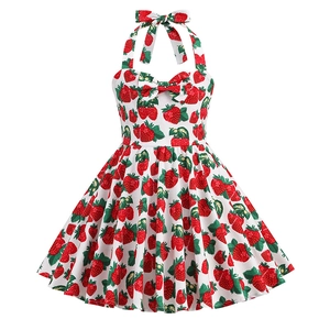 Detail of vintage girls halter dress featuring red strawberry print and bow accent