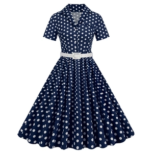 Detail of navy blue polka dot dress featuring a classic collar and white waist belt