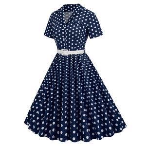 Macro detail of navy blue polka dot vintage dress with white waist belt and button front