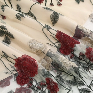 Close-up of elegant floral peony embroidery on beige mesh fabric for vintage V-neck dress
